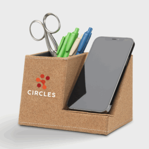 Support de bureau en liège avec smartphone et stylos.