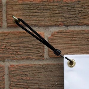 Bungee accrochant une bannière sur mur de briques.