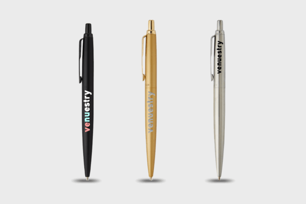 Trois stylos à bille : noir, doré, argenté.