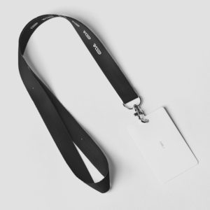 Badge avec cordon noir sur fond blanc.