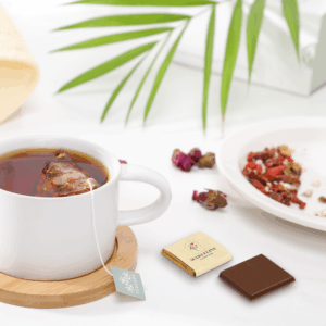 Tasse de thé avec chocolat et herbes séchées.