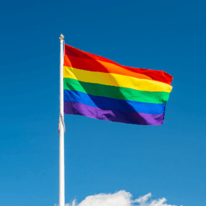 Drapeau arc-en-ciel flottant dans le ciel bleu.