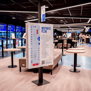 Salle moderne avec mobilier et panneau d'affichage.