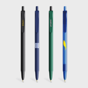 Quatre stylos bille colorés sur fond blanc.
