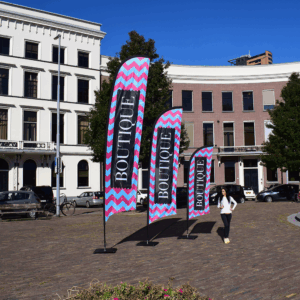 Drapeaux boutique sur une place pavée ensoleillée.