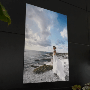 Femme en robe blanche sur falaise côtière.