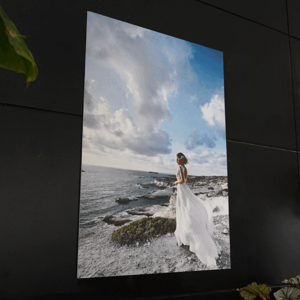 Femme en robe blanche sur falaise côtière.
