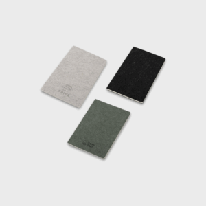 Trois carnets en feutre gris, noir et vert.