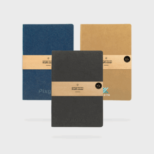 Carnets couverture kraft bleu, noir, marron empilés.