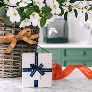 Cadeau élégant avec rubans et fleurs blanches.