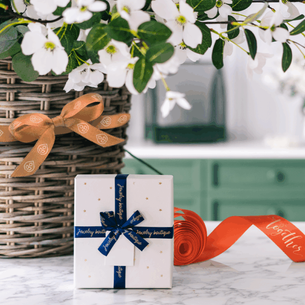 Cadeau élégant avec rubans et fleurs blanches.