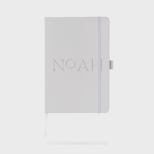 Carnet blanc avec élastique et nom en relief.