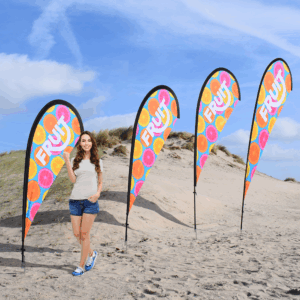 Femme avec drapeaux colorés sur la plage.